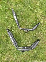 Two HTTMT J-style kayak roof rack carriers laid on grass