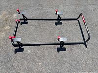 Full view of rectangular steel tire rack with red knobs and mounting plates