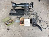 Full view of sewing machine with foot pedal, attachments, manual and parts