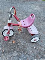 Side view of red Radio Flyer tricycle showing overall design and wear