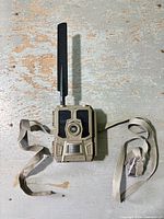 Front view of tan Reveal cellular trail camera with antenna attached
