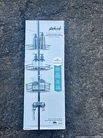 Front of boxed Richards matte black tension shower caddy