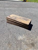 stack of stained wood boards on pavement