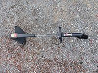 Full view of Toro string trimmer laid on gravel surface
