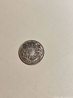 Reverse of 1942 Canadian 50-cent coin showing coat of arms and date