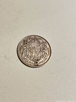 Reverse of 1944 Canadian 50-cent coin showing coat of arms and date