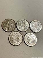 Five Canadian 50-cent coins arranged in row, dates visible