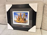 Framed print with corner protectors on couch