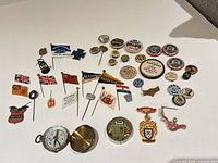 Overall view of entire lot showing pins, badges, medallions and two pocket compasses
