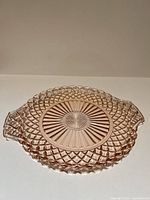 Top view of pink pressed glass platter showing entire design and handles