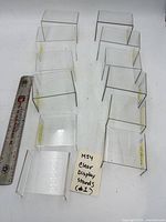 All 12 clear acrylic riser stands arranged with ruler for scale