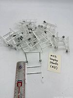 Pile of 20 small clear acrylic display stands with note identifying lot