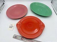 Three Fiesta platters in green, pink, red with ruler for scale