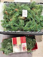 Loose pine garland with pinecones in tote; boxed garland beneath