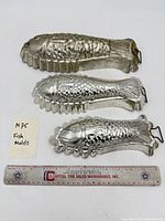 Three fish molds with ruler for scale