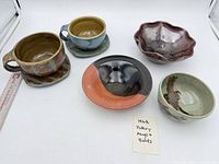 Group shot of two mugs with saucers and three bowls