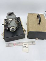 Projector with case and ruler for scale