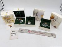 Overview of three open boxes showing the angel, flat ornament, and two ball ornaments with ruler for scale