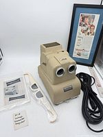 Full lot showing projector, viewer, manual, framed ad, power cord