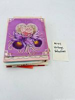 Stack of vintage Valentine cards showing floral heart design on top