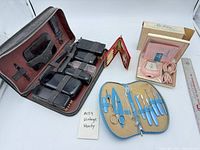 Overall lot showing brown grooming kit, blue manicure kit, pink shaver in box, red compact