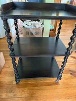 Front view of three-tier wood cart on casters