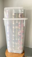 Clear Rubbermaid tub containing multiple wrapping paper rolls