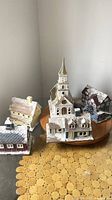 Five ceramic Christmas village buildings on wooden board