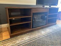 Full view of entertainment unit with fireplace insert and shelving