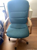 Front view of teal fabric swivel chair showing seat, backrest, armrests, casters