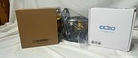 Brown Gizmodorks box, vacuum-sealed gold filament spool, white CC3D box