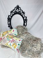 Throw blanket, mirror frame and unrelated pillows for scale