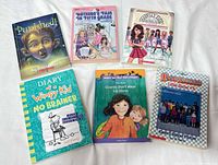 Six assorted paperback children’s books displayed on white surface