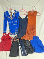 All items laid out: costume bodysuit, jumpsuit, dress, tops, shorts, leggings, joggers
