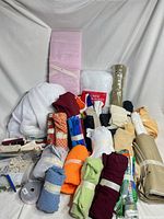 overall lot with multiple rolled fabrics, batting, packaged blanket and notions