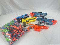 All five blasters and bag of darts on white background