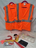 two orange reflective vests on hangers above assorted gear