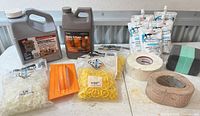 Overall view of all items on table, including jugs, texture pouches, spacers, spreader, tapes, sponge