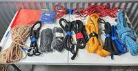 Full lot overview of assorted ropes, straps, flag and hardware on table