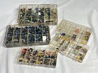 Five clear plastic organizers filled with buttons