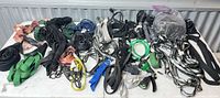 Full lot of assorted straps, cords, rope and hose nozzle spread on table
