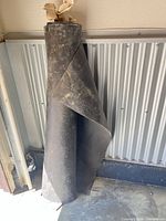 Full view of rolled black rubber membrane standing vertically