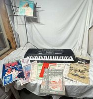 Overall lot with keyboard, stand, sheet music spread out