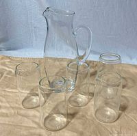 pitcher with five glasses arranged around