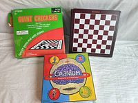 Front view of Cranium game box, Giant Checkers box, and wooden chess/checkers board