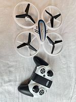 Top view of white Q45 drone and white/black remote controller on cloth background