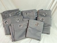 All eight folded gray curtain panels showing grommet tops