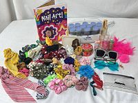Full lot overview showing hot rollers, hair accessories, body care products, sunglasses, and book