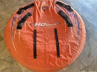 Full view of orange HO Sports Extreme towable tube showing graphics, handles, overall wear