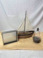 Sailboat model, shadow box, glass conch on metal base displayed together